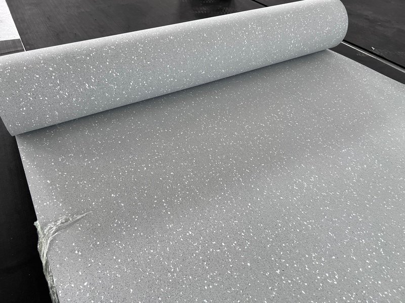 Une pile de rouleaux de revêtements de sol en caoutchouc de différentes épaisseurs, avec des options de 6 mm et 8 mm.